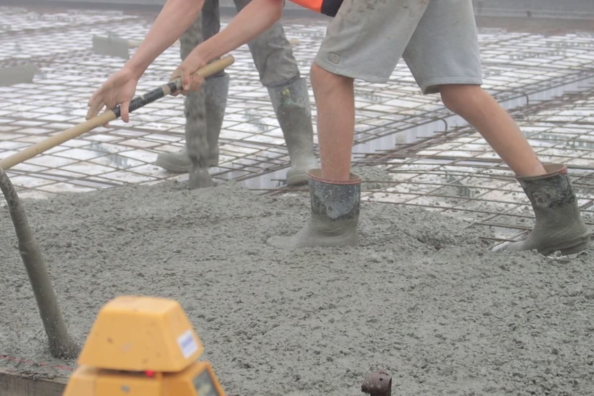 Concrete being placed and screeded to level on pour day, Cessnock